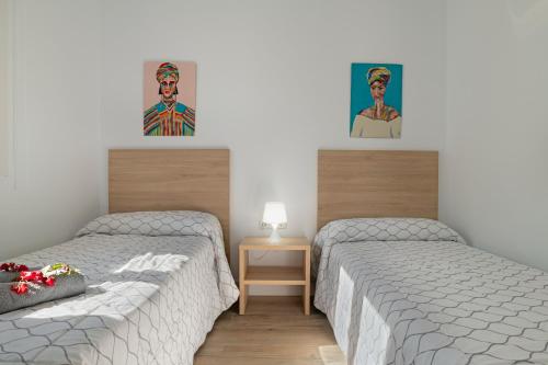 een slaapkamer met 2 bedden en een foto van een man bij Casa Azul in Conil de la Frontera
