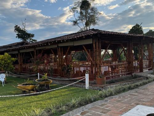 a wooden pavilion in a park with a yard at Ecohotel Santa Barbara in Circasia