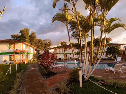 a resort with a swimming pool and palm trees at Ecohotel Santa Barbara in Circasia