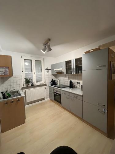 a kitchen with stainless steel appliances and a white refrigerator at Ferienwohnung Fuldaufer in Melsungen