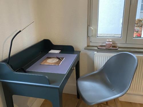 a blue desk with a chair next to a window at Ferienwohnung Fuldaufer in Melsungen
