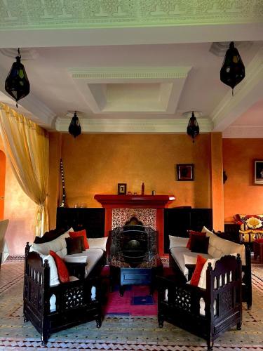 a living room with two beds and a fireplace at Villa Aalama in Marrakech