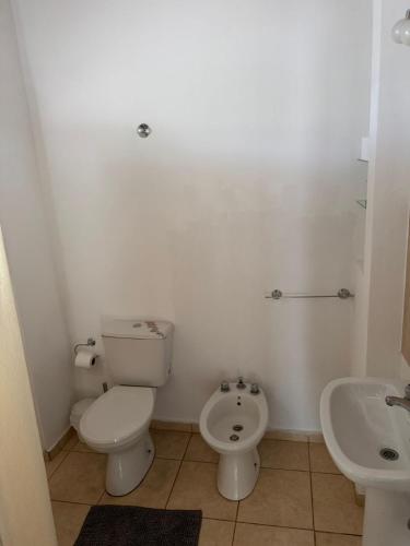 a white bathroom with a toilet and a sink at Ricon de malvones vintage in General Alvear