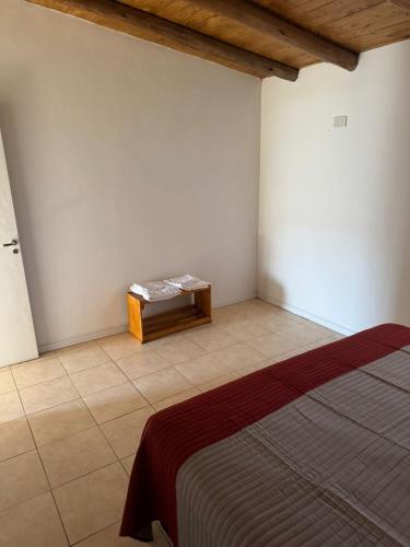 a bedroom with a bed and a table in the corner at Ricon de malvones vintage in General Alvear