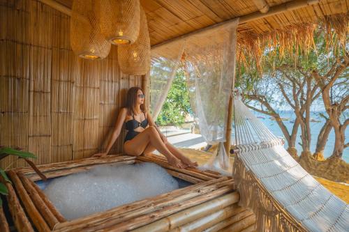 a woman in a bathing suit sitting in a tub at Bamboo Seaview Koh Larn Second Floor - 2nd Floor in Ko Sak