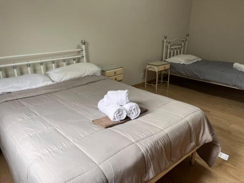 een slaapkamer met 2 bedden en opvouwbare handdoeken bij Keller Reservas in Resende