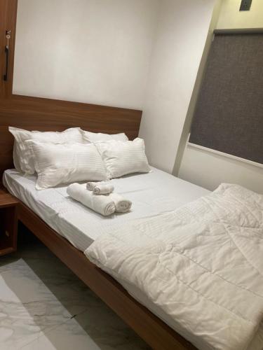 a bed with white sheets and two towels on it at a28 ORANGE BRICKS in Kolkata
