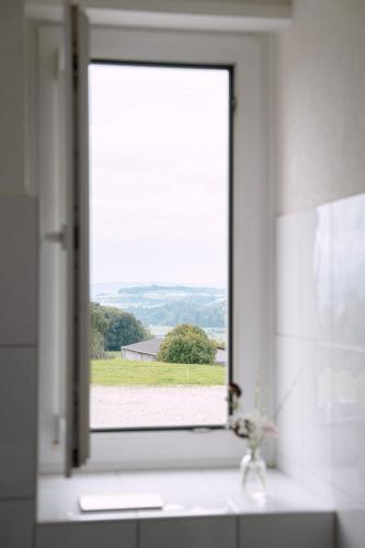 a window in a bathroom with a view of a field at Hotel & Restaurant Nollen in Hosenruck