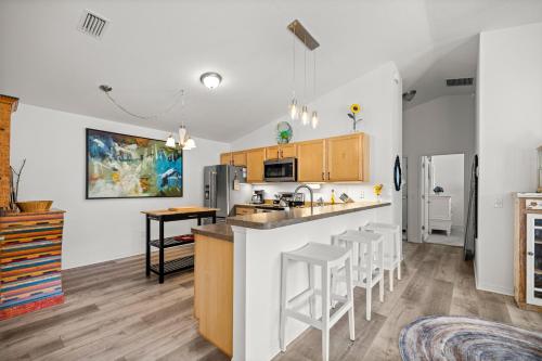 a kitchen with a counter and bar stools at Sunnyside Escape in The Villages With Golf Cart & BBQ in The Villages
