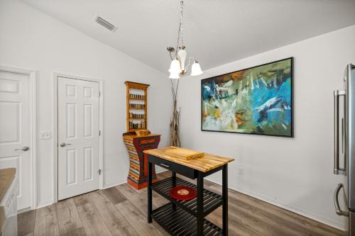 a room with a table and a painting on the wall at Sunnyside Escape in The Villages With Golf Cart & BBQ in The Villages