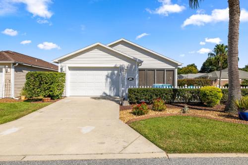 a house with a driveway and a garage at Sunnyside Escape in The Villages With Golf Cart & BBQ in The Villages