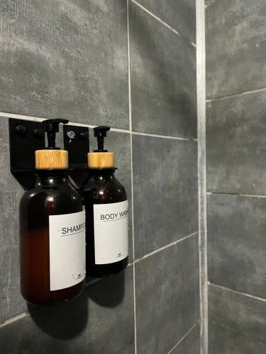 two bottles of honey are hanging on a wall at Appartement Chloé du lac in Montferrat