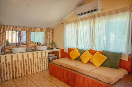 a bedroom with a couch with yellow and green pillows at Bamboo Seaview Koh Larn Second Floor - 2nd Floor in Ko Sak