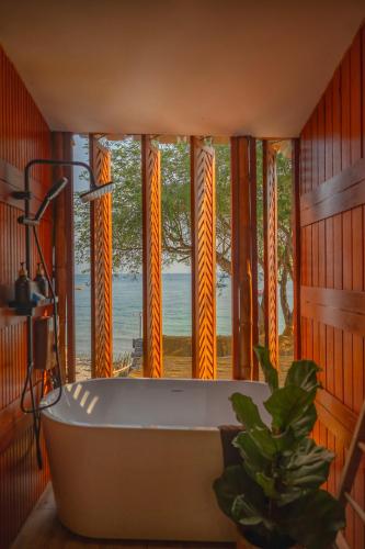 a bath tub in a room with a view of the ocean at Bamboo Seaview Koh Larn Second Floor - 2nd Floor in Ko Sak