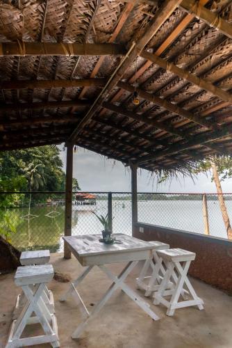 a picnic table and two chairs under a roof at Juula lagoon resort in Dodanduwa