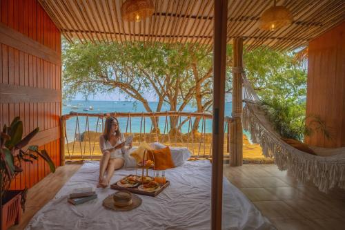 a woman sitting on a bed in a hammock at Bamboo Seaview Koh Larn Second Floor - 2nd Floor in Ko Sak