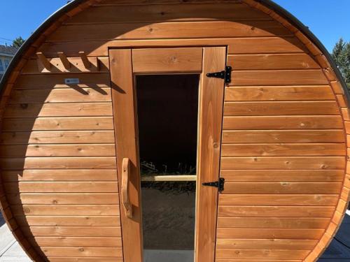 a large wooden dog house with a door at Auberge Matha in Saint-Jean-de-Matha