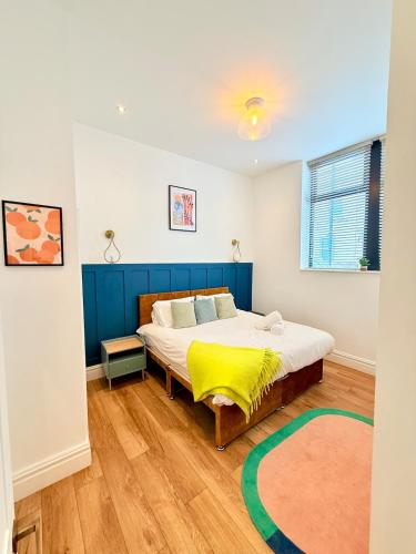 a bedroom with a bed with a yellow blanket on it at The City Nest - Sleeps 7 - Free Off Street Parking in Bristol