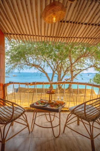 a table and two chairs on a porch with a tree at Bamboo Seaview Koh Larn Second Floor - 2nd Floor in Ko Sak