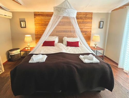 Un dormitorio con una cama grande con dosel. en Firefly Farm, en KwaNibela