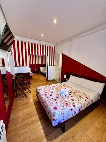 a bedroom with a bed with a red and white stripes at Hostal La Casa de La Plaza in Madrid