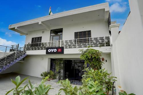 a white building with an omg sign on it at Hotel O Ujala Guest House in Varanasi