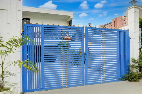 a blue gate in front of a white building at Hotel O Ujala Guest House in Varanasi