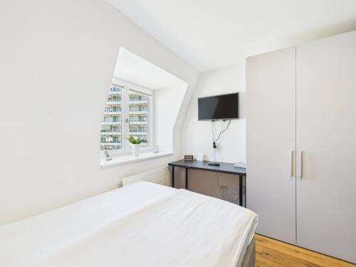 a white bedroom with a bed and a desk at SCHNYDER'S HOME - Studio_1 in Rapperswil-Jona