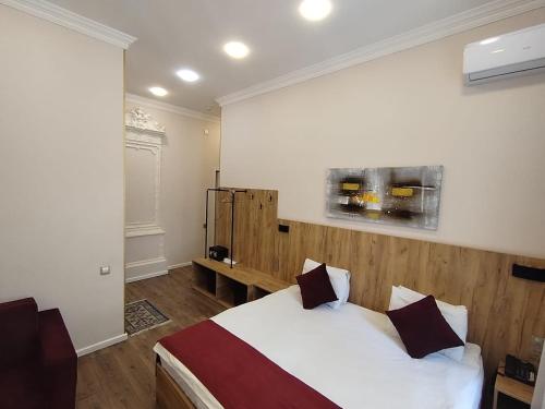 a bedroom with a bed with a wooden headboard at L10nd-on Hotel in Baku