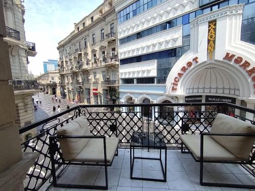 a balcony with two chairs and a view of a street at L10nd-on Hotel in Baku