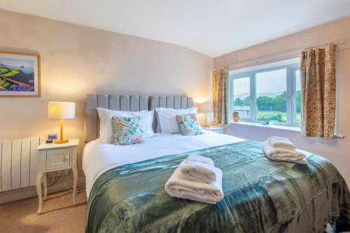 a bedroom with a bed with towels on it at Butlers Cottage in Hardraw