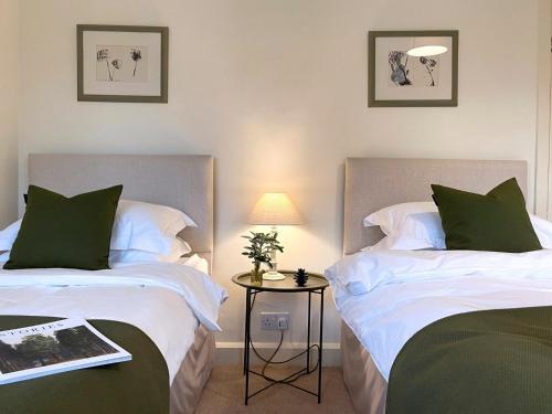 a bedroom with two beds and a table with a book at 4 Bed in Goathland G0042 in Goathland