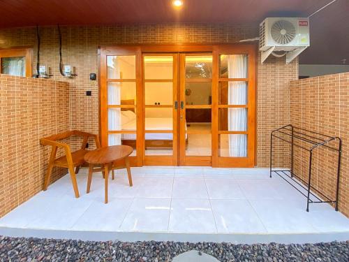 a room with a table and a wooden door at Malaka pedati homestay in Bingin Beach