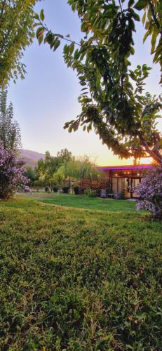 a building in a field with trees and flowers at GreenField Resort in Yeghegnadzor
