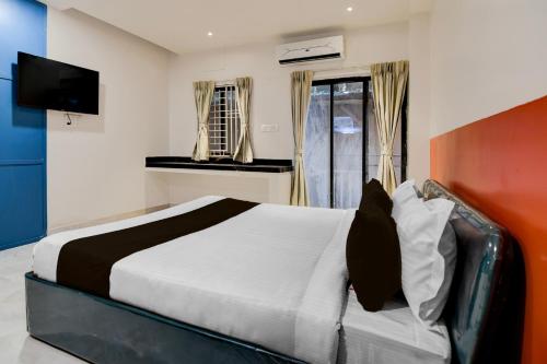 a bedroom with a large bed and a television at Hotel O Avigna Premium in Bhubaneshwar