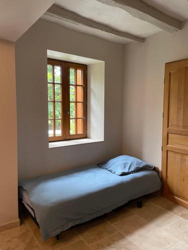 a bed in a room with a window at Gîte au cœur de la vallée de la Loire in Bléré
