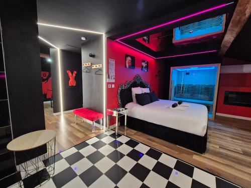 a bedroom with a bed and a red wall at L'Interdit Suite Luxe Romantique Spa Balneo Sauna Hammam in Serrières
