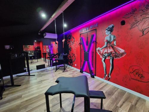 a room with a red wall with a woman in a pink dress at L'Interdit Suite Luxe Romantique Spa Balneo Sauna Hammam in Serrières