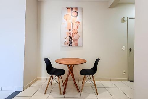 a table and two chairs in front of a wall at Lindo apê pertinho de tudo in Ourinhos