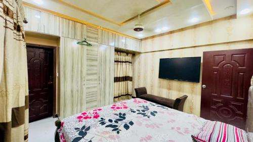 een slaapkamer met een bed en een flatscreen-tv bij Luxury 2BR Near Icon 36 2 AC, 2 TV & City View in Karachi