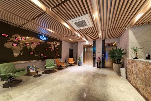 um lobby de escritório com cadeiras verdes e um mapa do mundo em Capace Hotel Gangnam em Seul