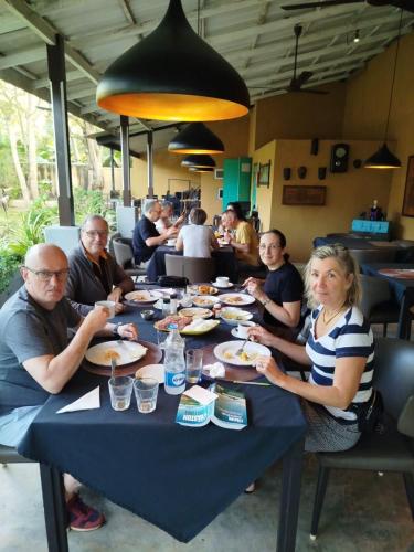 a group of people sitting at a table eating food at Royal Rock Sigiriya in Sigiriya