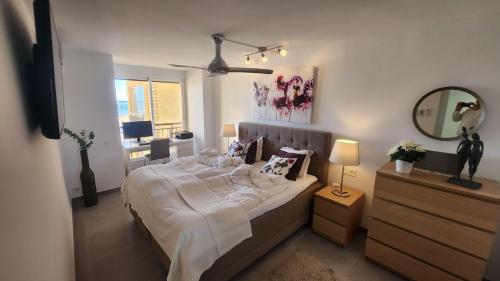 a bedroom with a large bed and a mirror at Sea View And Luxury On The Beach in Torrevieja