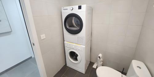 a washing machine in a bathroom next to a toilet at Sea View And Luxury On The Beach in Torrevieja