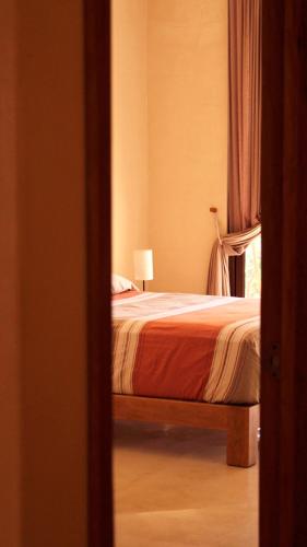 a bedroom with a bed with a lamp and a window at Yax Kiin Casa Boutique in Puerto Morelos