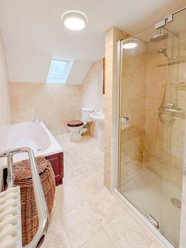 a bathroom with a tub and a shower and a toilet at Hainford Cottage in Hainford