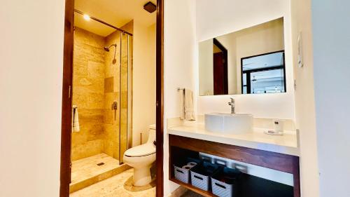 a bathroom with a sink and a toilet and a mirror at Ipana Luxury Suites By Caribe Rentas in Playa del Carmen