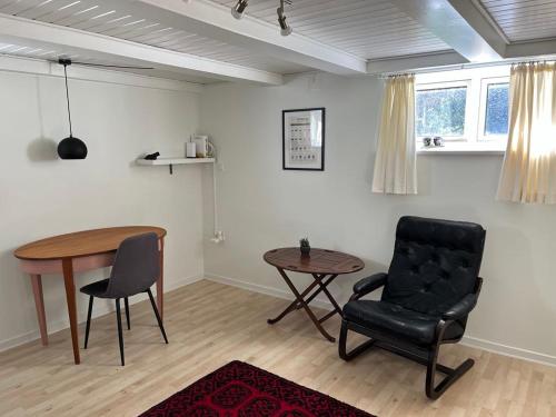a living room with a chair and a table at Lunderskov og tæt på Legoland og Hansenberg veterinær in Lunderskov