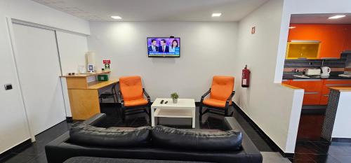 a living room with a couch and orange chairs at Original Apartments in Albufeira