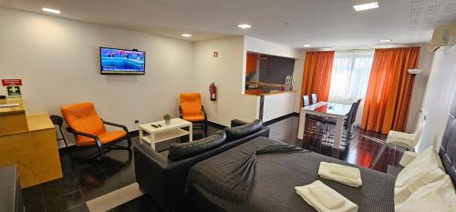 a living room with a bed and two chairs at Original Apartments in Albufeira